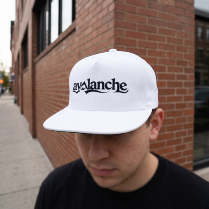 Avalanche Flat Bill Cap worn at a brick building corner