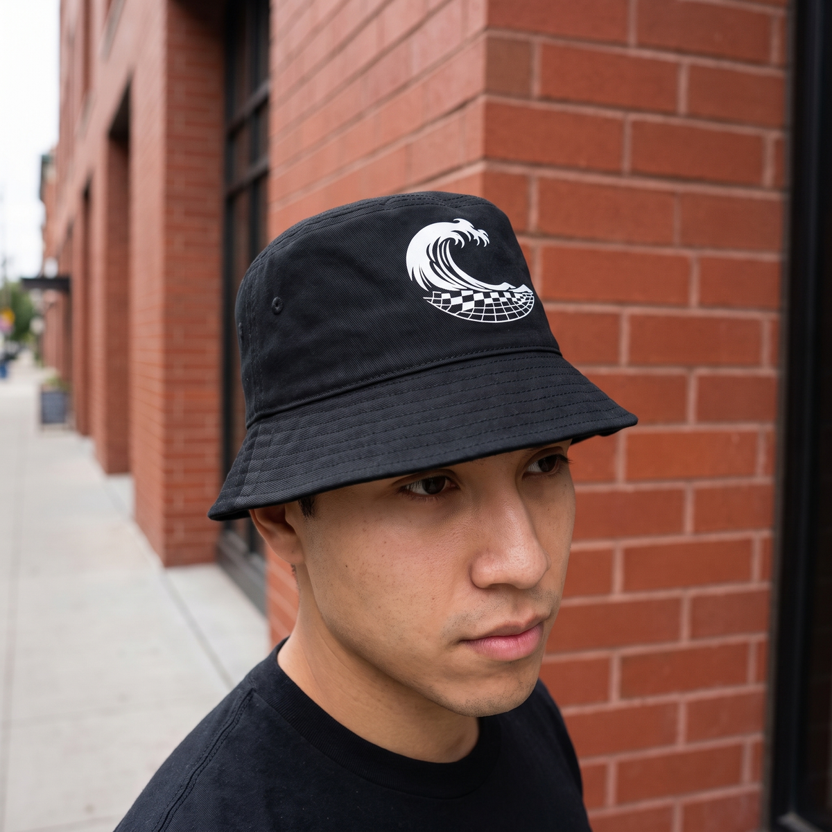 Wave Grid Bucket Hat worn at a brick building corner